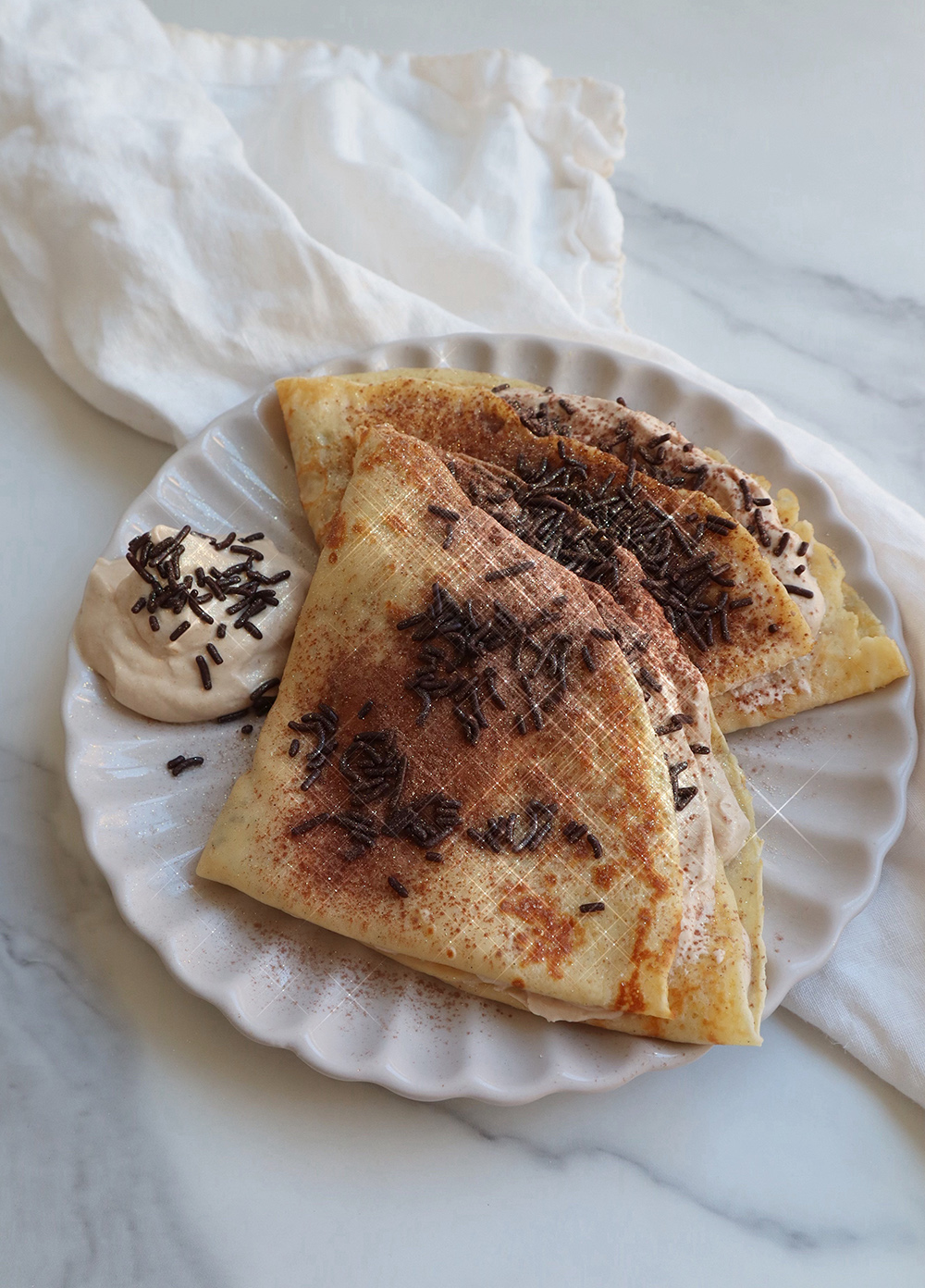 Tiramisu Crepes with chocolate sprinkles on a plate
